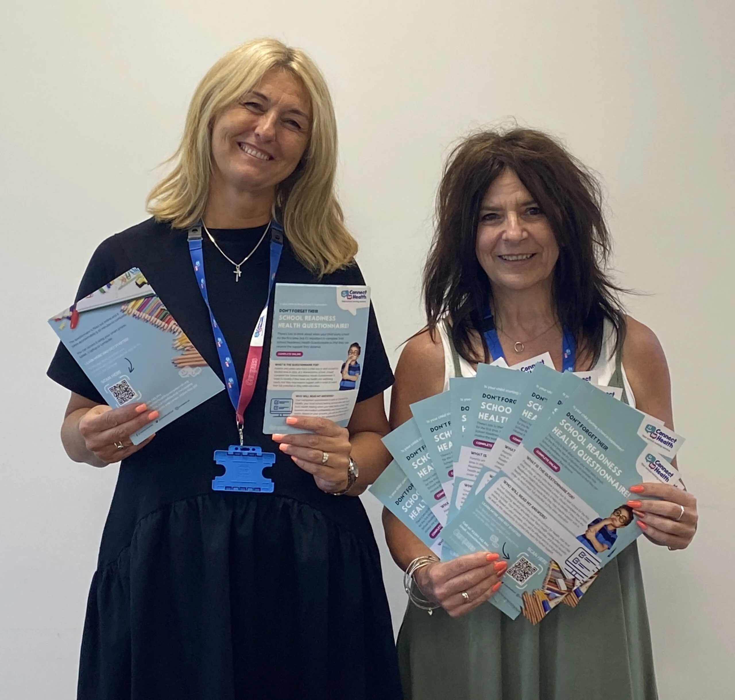 2 members of the connect for health team holding promotional flyers and posters.
